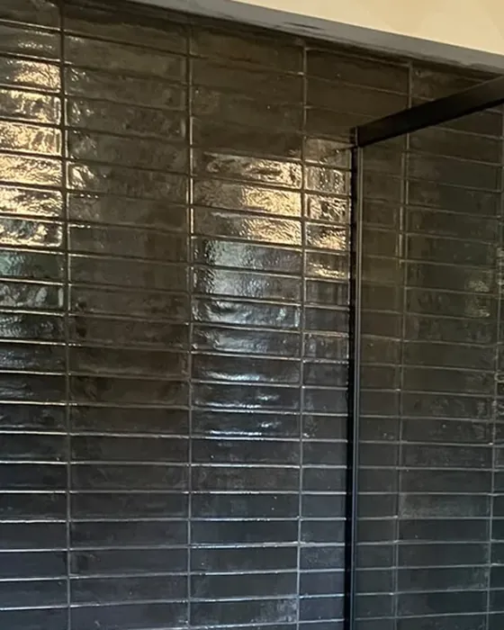 Faïence brillante sombre dans une douche rénovée par Fornillo
